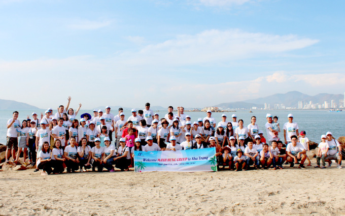 Đoàn khách đến từ Công ty Cổ phần Tập đoàn Mạnh Hùng chụp ảnh lưu niệm tại bãi biển Nha Trang